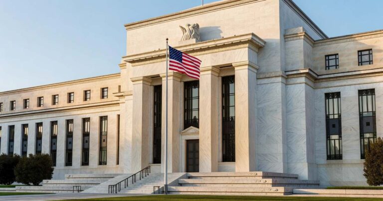 The marble neoclassical facade of the United States Federal Reserve headquarters building in Washington photographed from the plaza with tall fluted stone columns, an American flag on a pole, wide granite steps, and a clear sky in warm late afternoon light