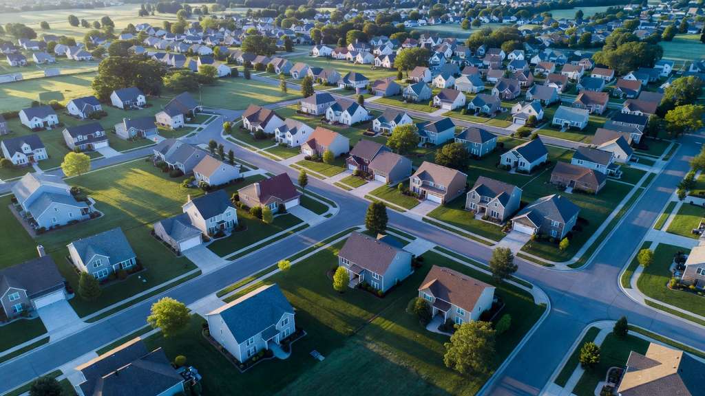 Aerial view of an American suburban housing development at sunrise, the housing stock behind the mortgage bonds the Federal Reserve holds